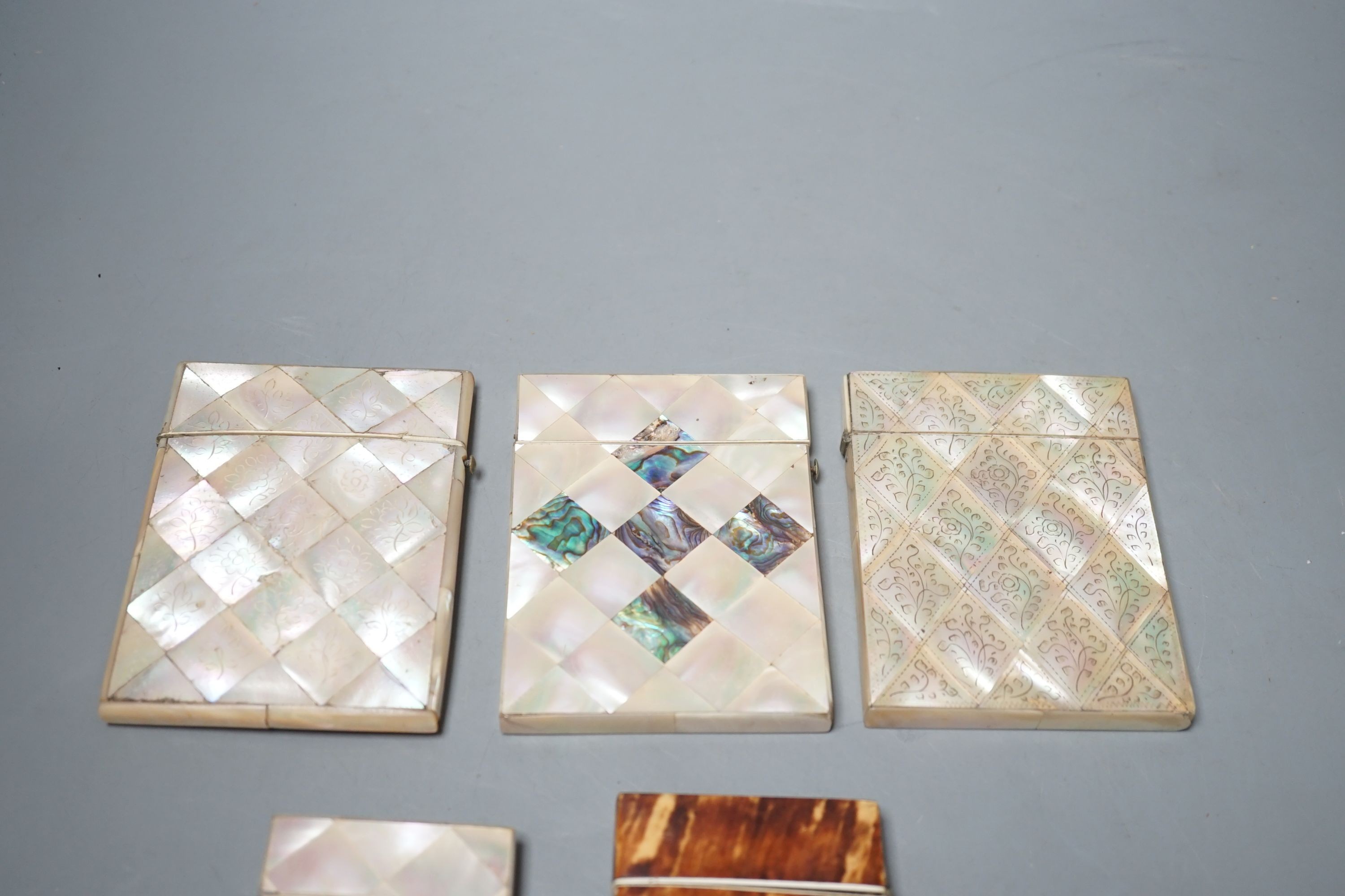 A selection of four mother of pearl card cases, together with another tortoiseshell card case inlaid with bone (5)